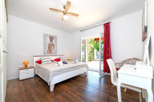 una camera da letto con un letto e un ventilatore a soffitto di Villa Mila Murter a Murter