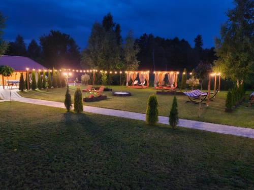 a garden at night with lights in the background at ZIELONA DOLINA - kompleks dla rodzin z dziećmi in Mikołajki