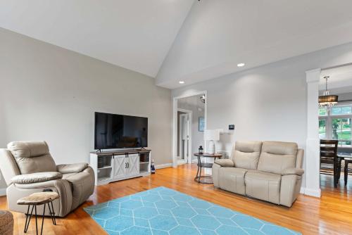 a living room with two chairs and a flat screen tv at Leeloo's on the Lake - Sleeps 12 in Lexington