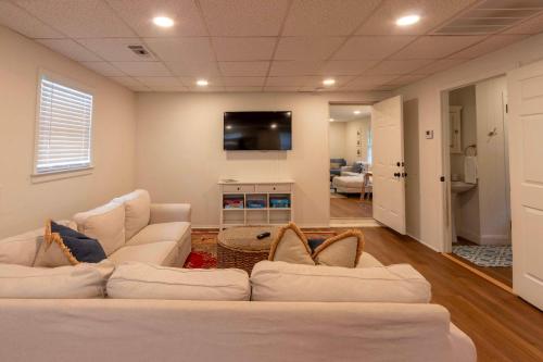 a living room with white couches and a flat screen tv at 4 BR Sleeps 10 Near UGA & Downtown in Athens
