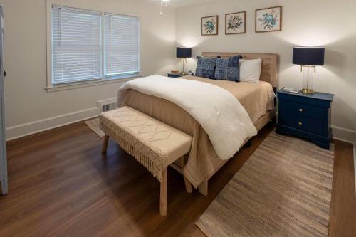 a bedroom with a bed with a bench and a window at 4 BR Sleeps 10 Near UGA & Downtown in Athens