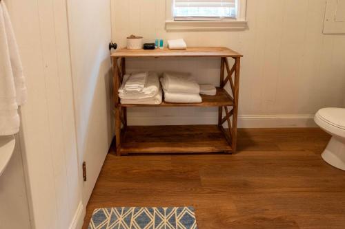 a bathroom with a shelf with towels and a toilet at 4 BR Sleeps 10 Near UGA & Downtown in Athens