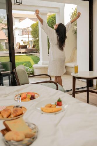 a woman in a white dress standing in front of a table at Fairfield by Marriott Goa Benaulim in Benaulim