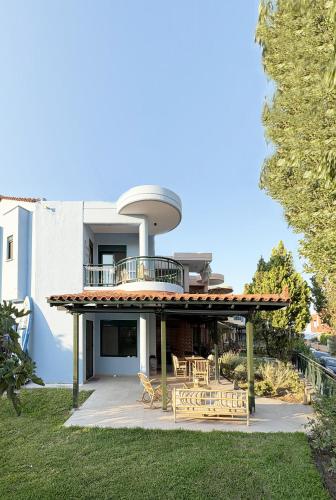 a house with a balcony and a table and chairs at Nikiti Blue house 30m from the beach with sea view in Nikiti