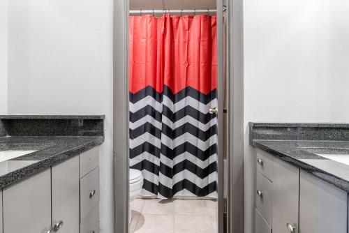 a bathroom with a red and black shower curtain at Home is Where the Arch is - Across from UGA in Athens