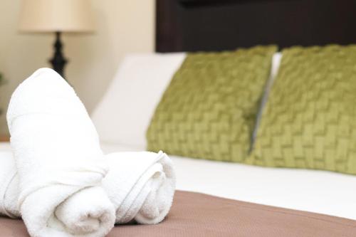 a pile of towels sitting on top of a bed at Hotel Partenon Beach in La Ceiba