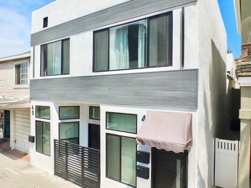 a white building with windows and an awning at Beach & Bay Retreat - Full of Amenities in Long Beach