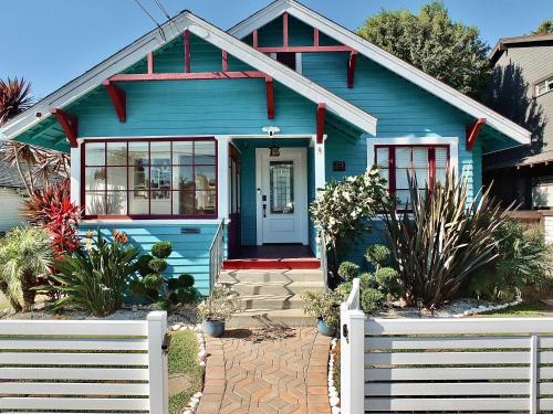a blue house with a white fence in front of it at Beach City Craftsman - Walk to Beach in Long Beach