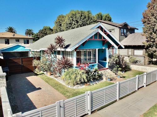 a house with a white fence in front of it at Beach City Craftsman - Walk to Beach in Long Beach