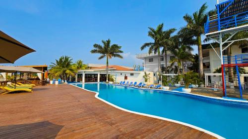 Una piscina vacía en un complejo turístico con palmeras. en Hotel Partenon Beach, en La Ceiba