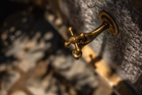 a close up of a brass faucet on a clock at Alsalos Apartment in Kardamili
