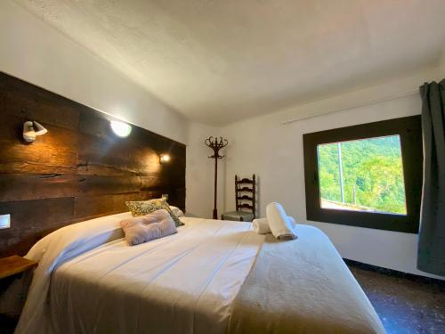 BrugueraにあるHostal Molinéの窓のある大きな白いベッドのある寝室