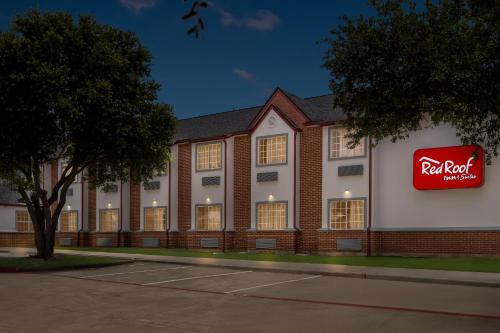 a red roof hotel with a sign on the side of it at Red Roof Inn & Suites Euless - DFW Airport Southwest in Euless