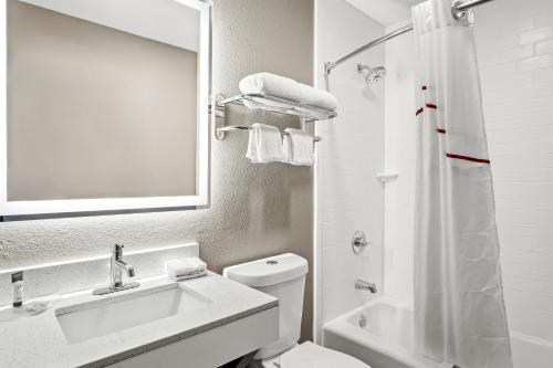尤利斯Red Roof Inn & Suites Euless - DFW Airport Southwest的带水槽、马桶和镜子的浴室