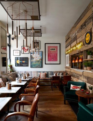 a restaurant with a row of tables and chairs at Artist Residence London in London
