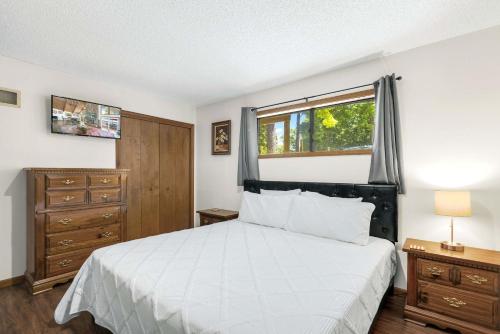 a bedroom with a white bed and a window at Boondock Bliss - Lakefront with Private Dock Sleeps 15 in Sunrise Beach