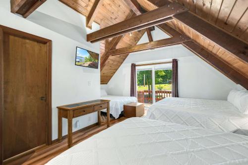 a bedroom with two beds and a desk and a window at Boondock Bliss - Lakefront with Private Dock Sleeps 15 in Sunrise Beach