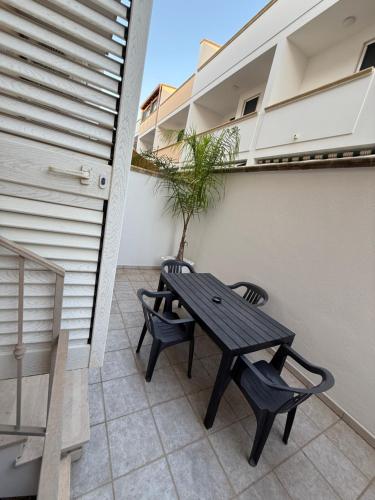 a patio with a wooden table and two chairs at Leo Rooms & Sea in Torre San Giovanni Ugento