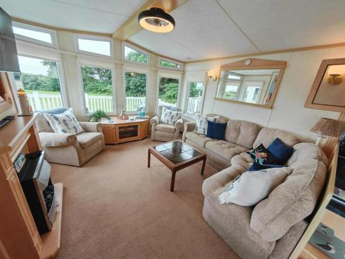 a living room with a couch and a table at Summer Dreams in Amroth