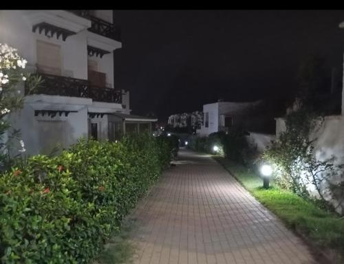 a walkway leading to a building at night at Sun Darb in Dar Bouazza
