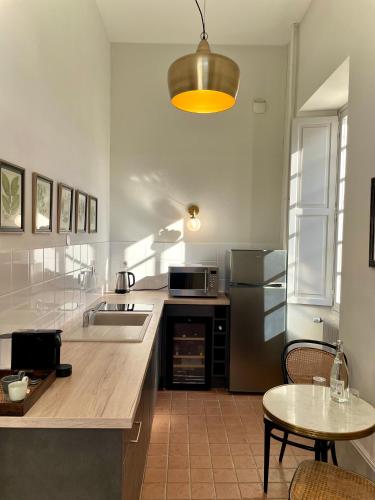 - une cuisine avec un comptoir, une table et un évier dans l'établissement Hôtel Particulier, Maison Jazey., à Semur-en-Auxois