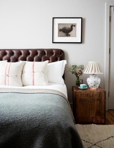 a bedroom with a bed and a table with a lamp at Artist Residence London in London