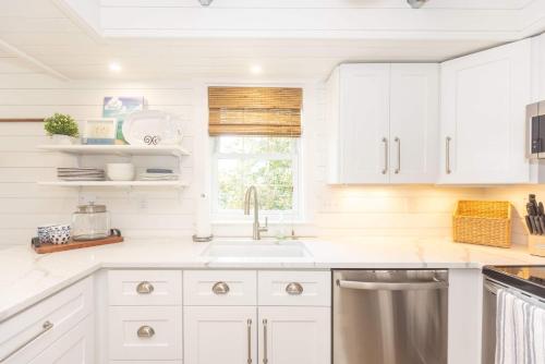 a white kitchen with a sink and a window at Heaven on Earth 2 BDR Fontana Flat Walk to Lake in Lake Geneva