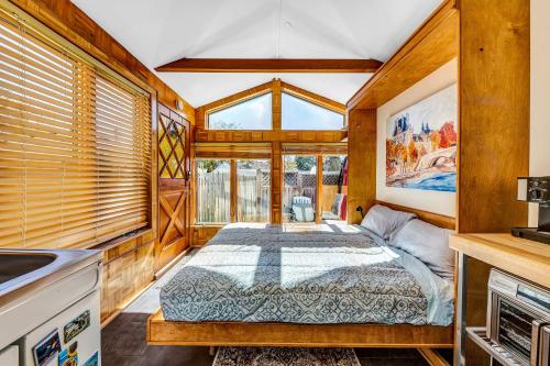 a bedroom with a bed in a room with windows at Snuggle Inn - A Romantic Retreat in Carmel