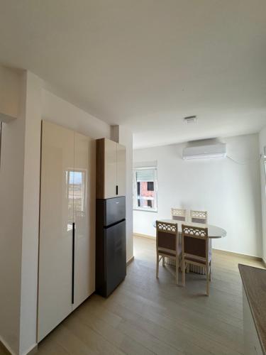 a kitchen and dining room with a refrigerator and a table at Aron Apartment in Tuzi