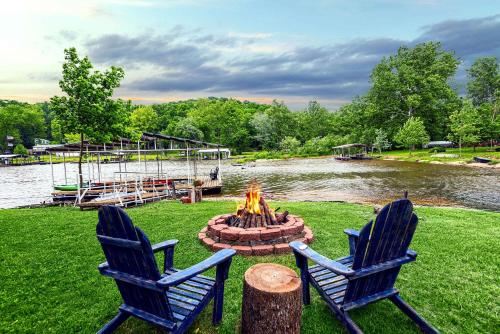 two blue chairs and a fire pit next to a river at Cozy Cove Cabin - The Perfect Ozark Retreat in Roach