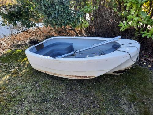 a small white boat sitting on the grass at Chalet V14 4pers in Makkum