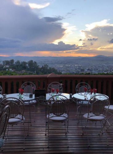 a table and chairs on a deck with a view at Lokanga Boutique Hotel in Antananarivo