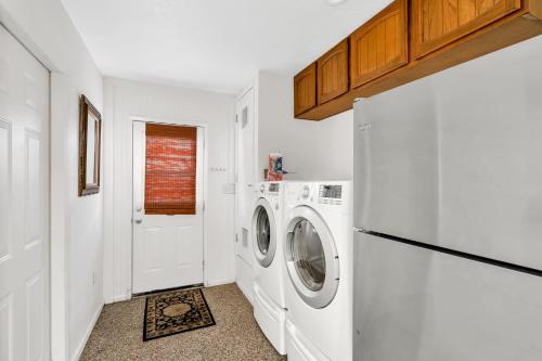 a white laundry room with a washer and dryer at CC Cabin - Full Game Room & Wrap Around Deck in Shaver Lake