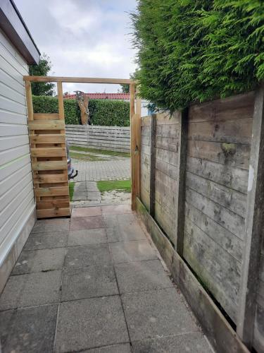 an entrance to a fence with a wooden gate at Chalet V14 4pers in Makkum
