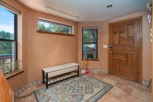 a room with a door and a bench and a rug at Happy Days Retreat with Private Pool in Bass Lake Annex