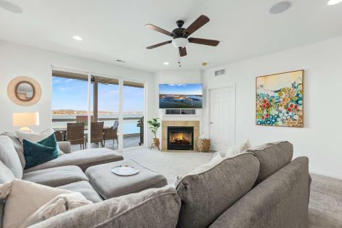 オーセージ・ビーチにあるPanoramic Sunset Escape - Waterfront Condo for 7のソファと暖炉のあるリビングルーム