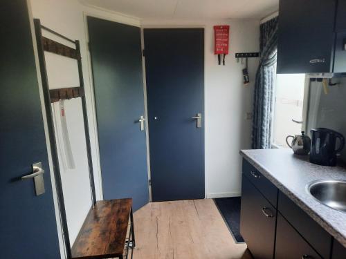 a kitchen with two blue doors and a sink at Chalet V14 4pers in Makkum