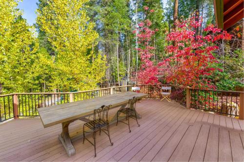 a wooden bench sitting on a deck with trees at Beautiful 3bd Sanctuary Inside Yosemite in Wawona