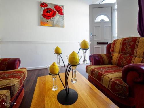 a living room with two couches and a table with yellow candles at Cornwallis House in Stoke on Trent