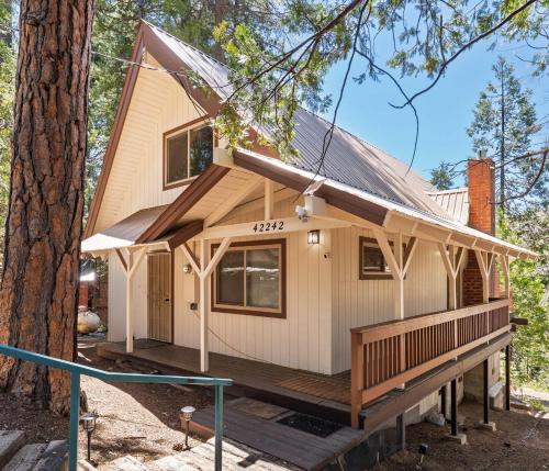 a tiny house in the woods with a porch at Cavu Cabin - A Classic Mountainside Escape in Shaver Lake