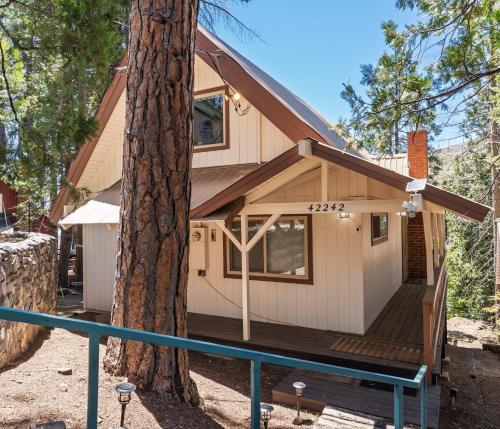 a cabin in the woods with a tree at Cavu Cabin - A Classic Mountainside Escape in Shaver Lake