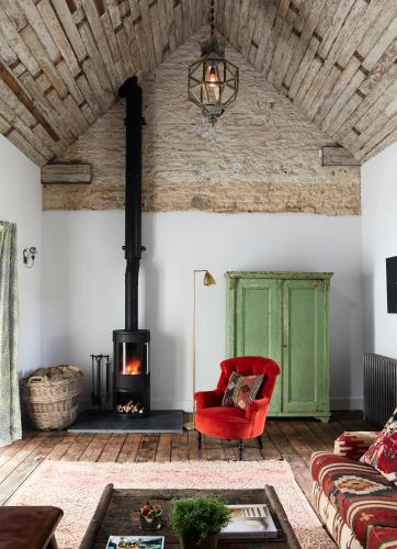 a living room with a red chair and a fireplace at Artist Residence Oxfordshire in Oxford