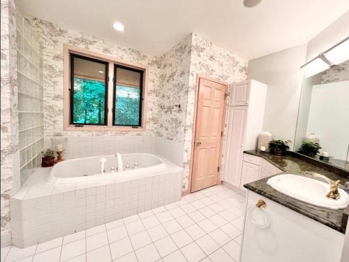 a white bathroom with a tub and a sink at Spacious 4 BDR Home in Desirable Abbey Springs in Lake Geneva