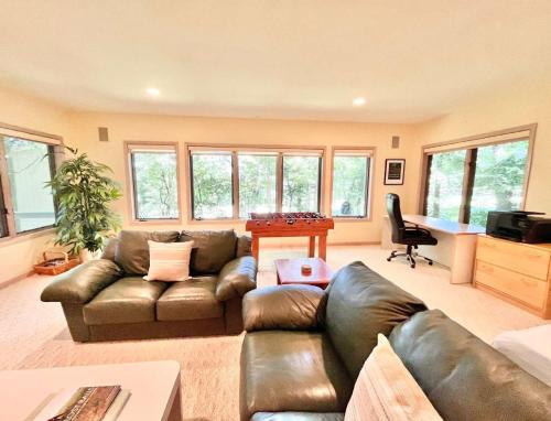 a living room with a leather couch and a table at Spacious 4 BDR Home in Desirable Abbey Springs in Lake Geneva