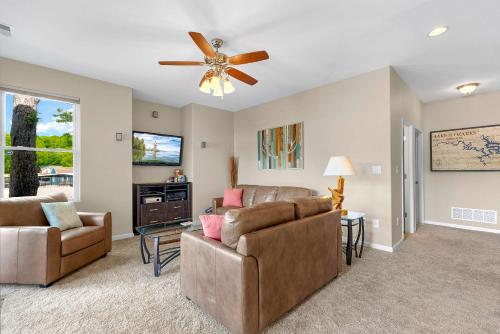 a living room with a couch and a ceiling fan at Trails End Hideaway - Waterfront in Sunrise Beach