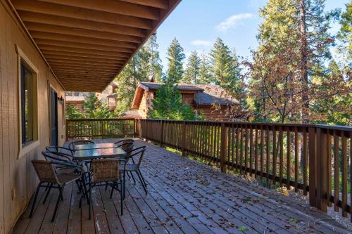 a patio with a table and chairs on a deck at Yosemite Quail - Nestled in with a View in Yosemite West