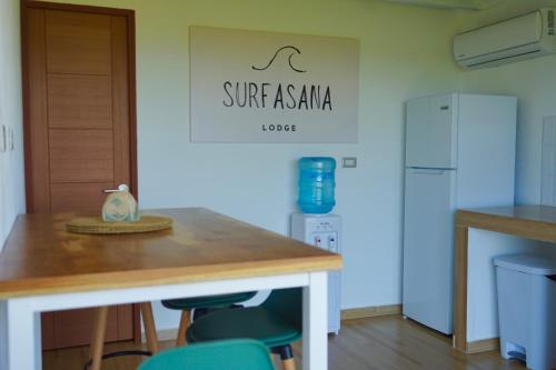 a kitchen with a table and a refrigerator at SurfAsana Lodge in Santa Catalina