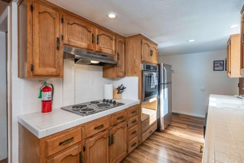 a kitchen with wooden cabinets and a stove at Yosemite Aviary and Quail Within Yosemite - 2 Separate Family Units Welcoming Up To 14 Guests in Yosemite West