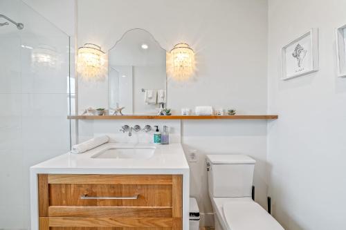 a bathroom with a sink and a toilet and a mirror at Your Dream Seaside Vacation Charming 2 BDR Home in Seaside