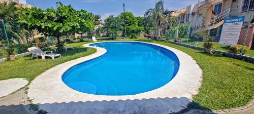 a swimming pool in the middle of a yard with a bench at Casa con Alberca en Ixtapa Zihuatanejo Internet in Ixtapa
